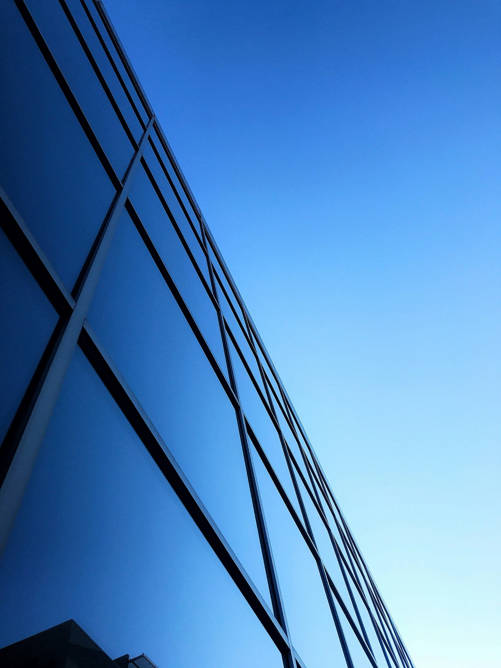 the blue sky reflected in the side of an office building