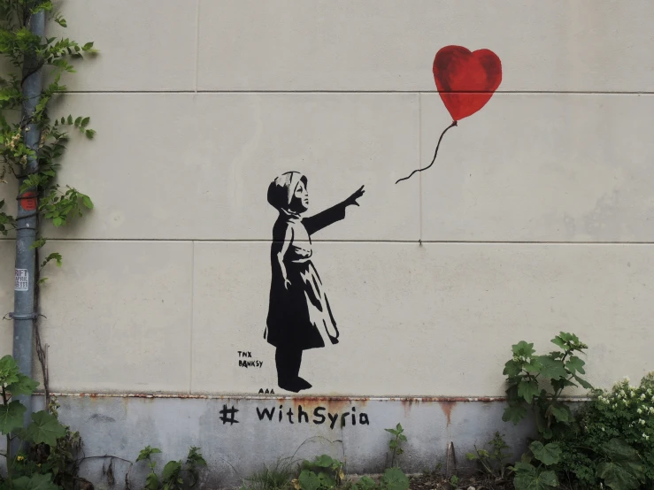 a painting of a girl with a heart on the side of a building