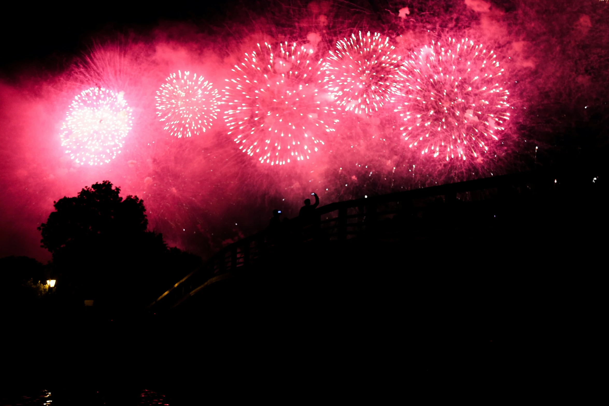 red fireworks exploding in the air next to a street