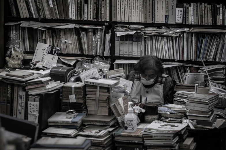 there is a person sitting in a book case reading