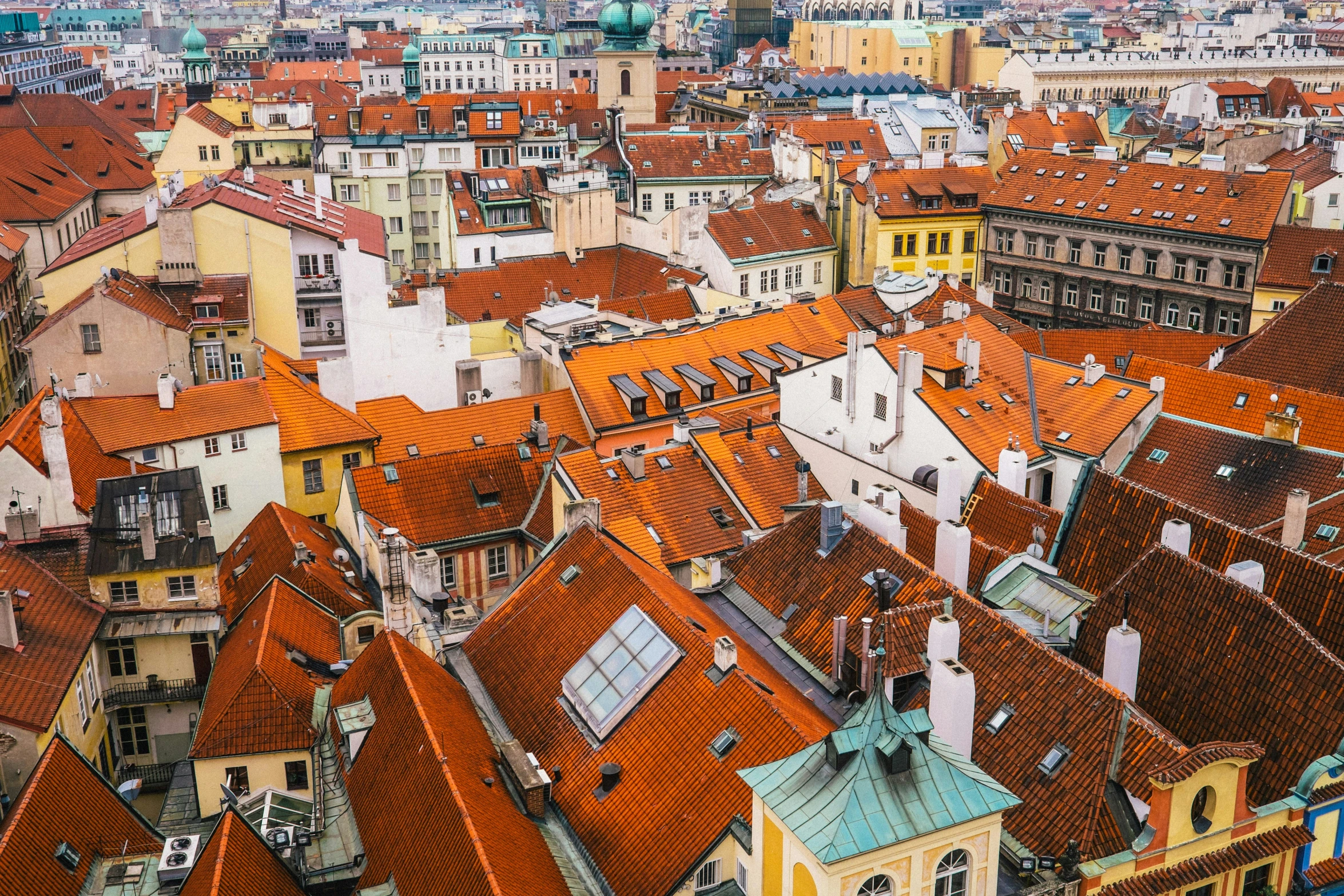 a city filled with tall buildings covered in red roofs