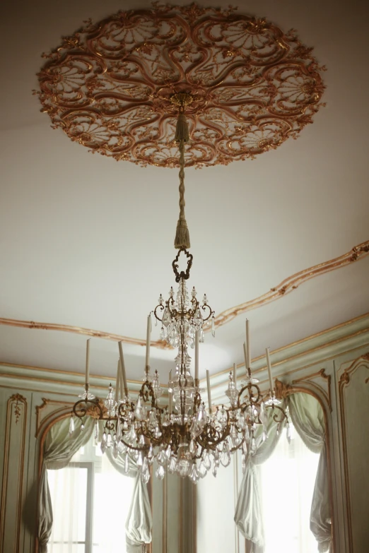 a chandelier in the middle of a room with many curtains