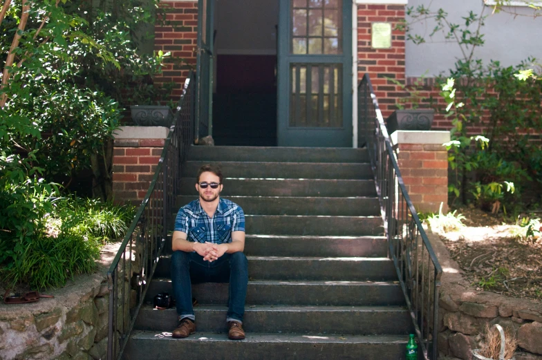 a man sitting on the steps of a house