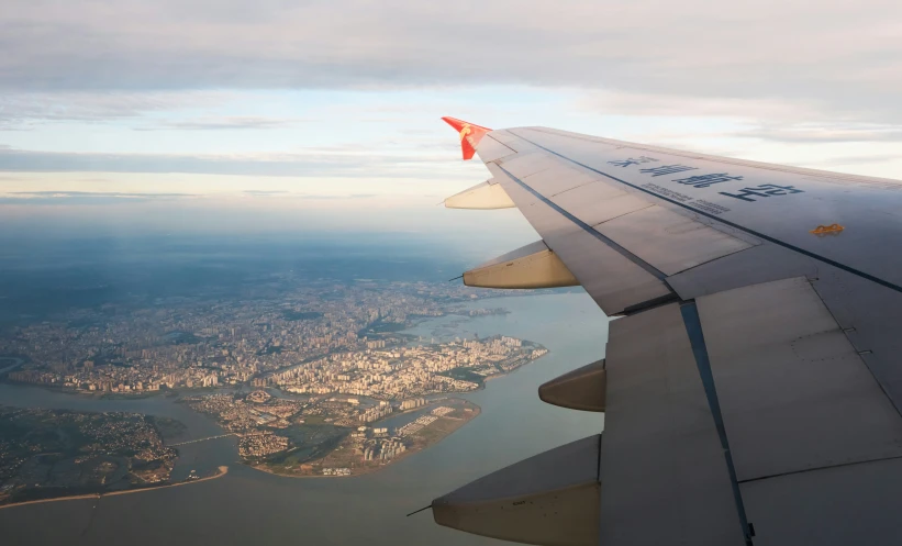 an airplane wing with a city view in the background