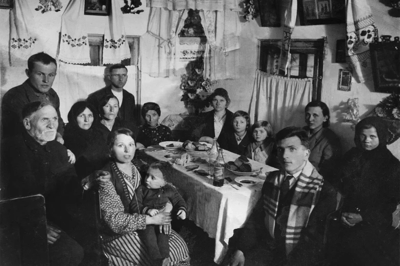 the people are gathered around a long dining table