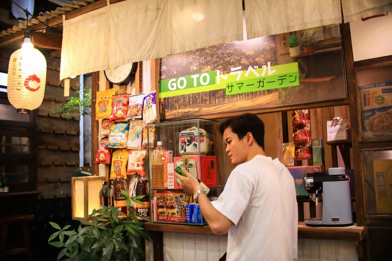 a man standing next to a store window in front of a bunch of snacks