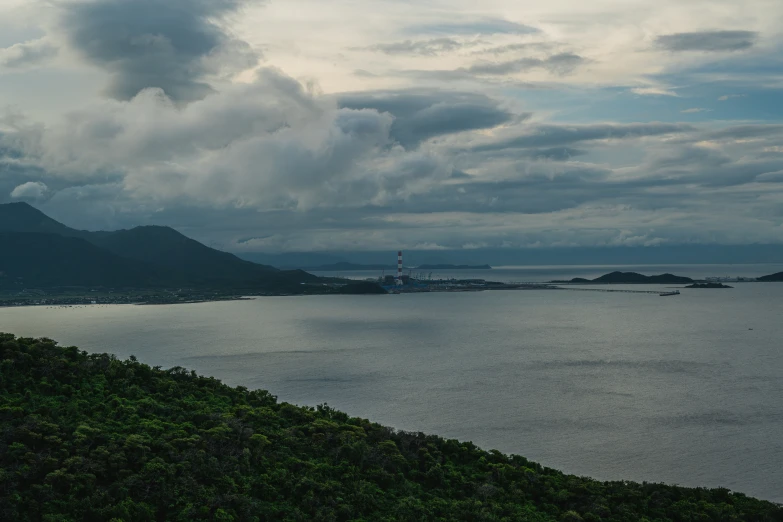 an open body of water with hills and clouds