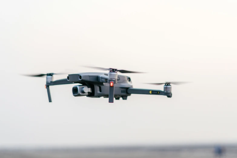 a grey and black colored helicopter flies through the air