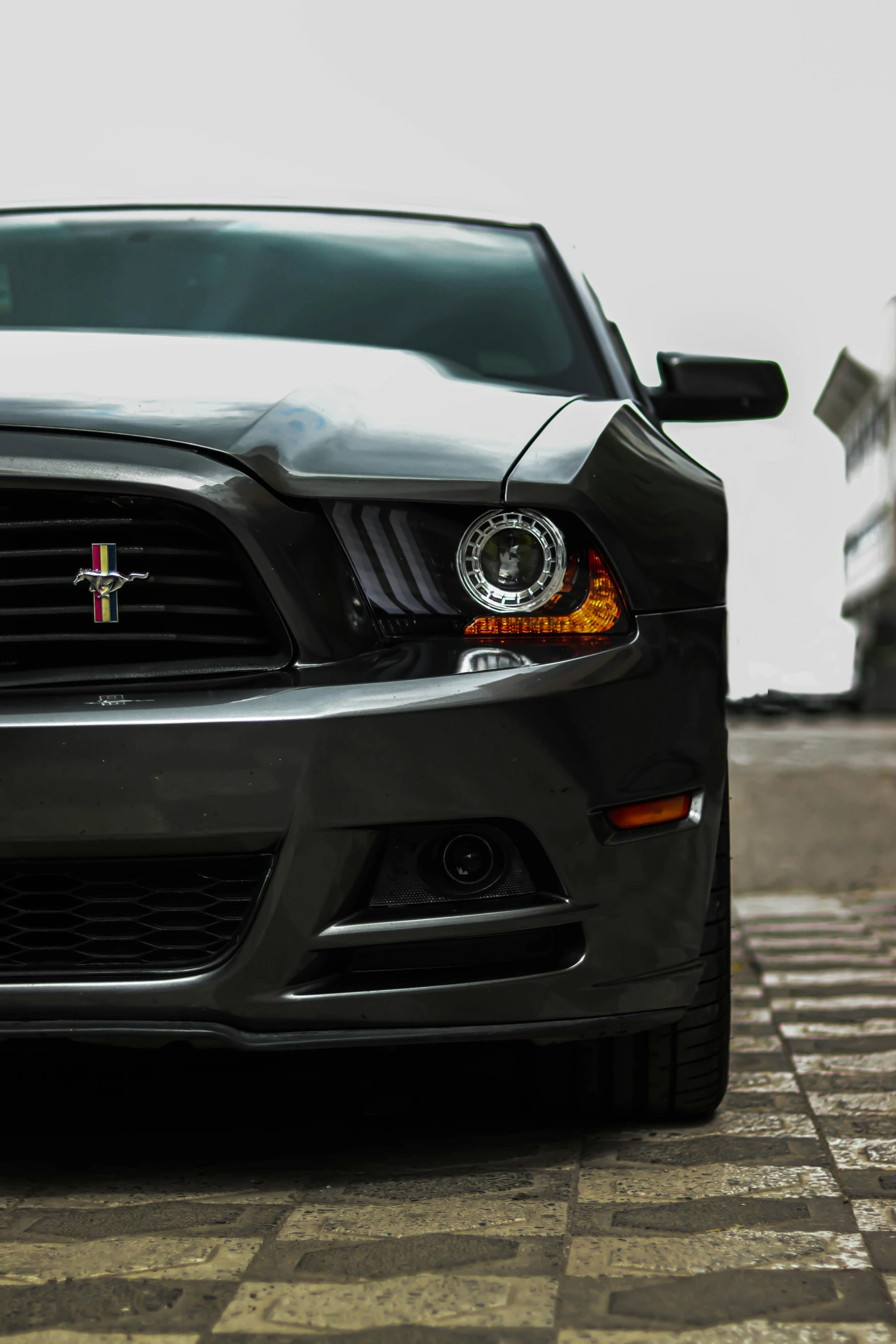 a black mustang car parked next to the ocean