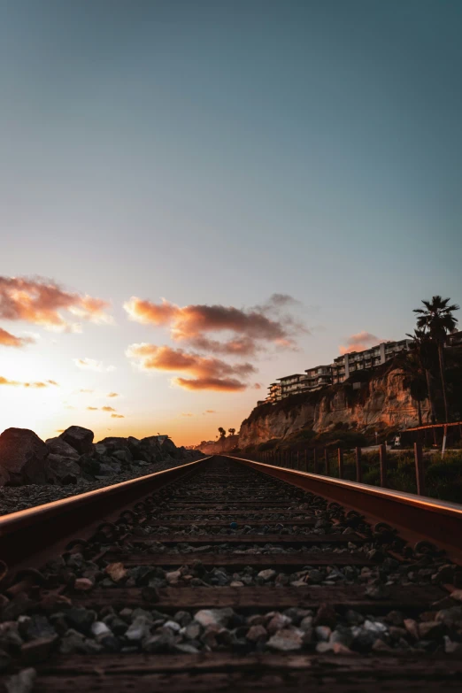 a train track on a hill side at sunset