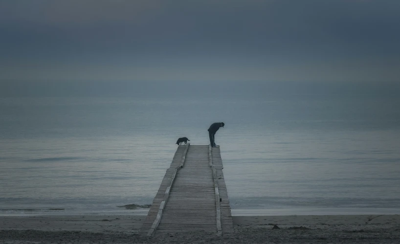 a person standing on a dock that is facing the water