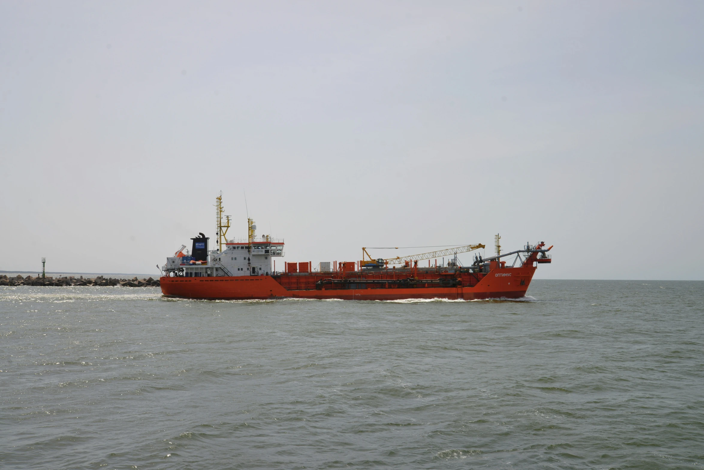 an orange ship is sailing on the open ocean