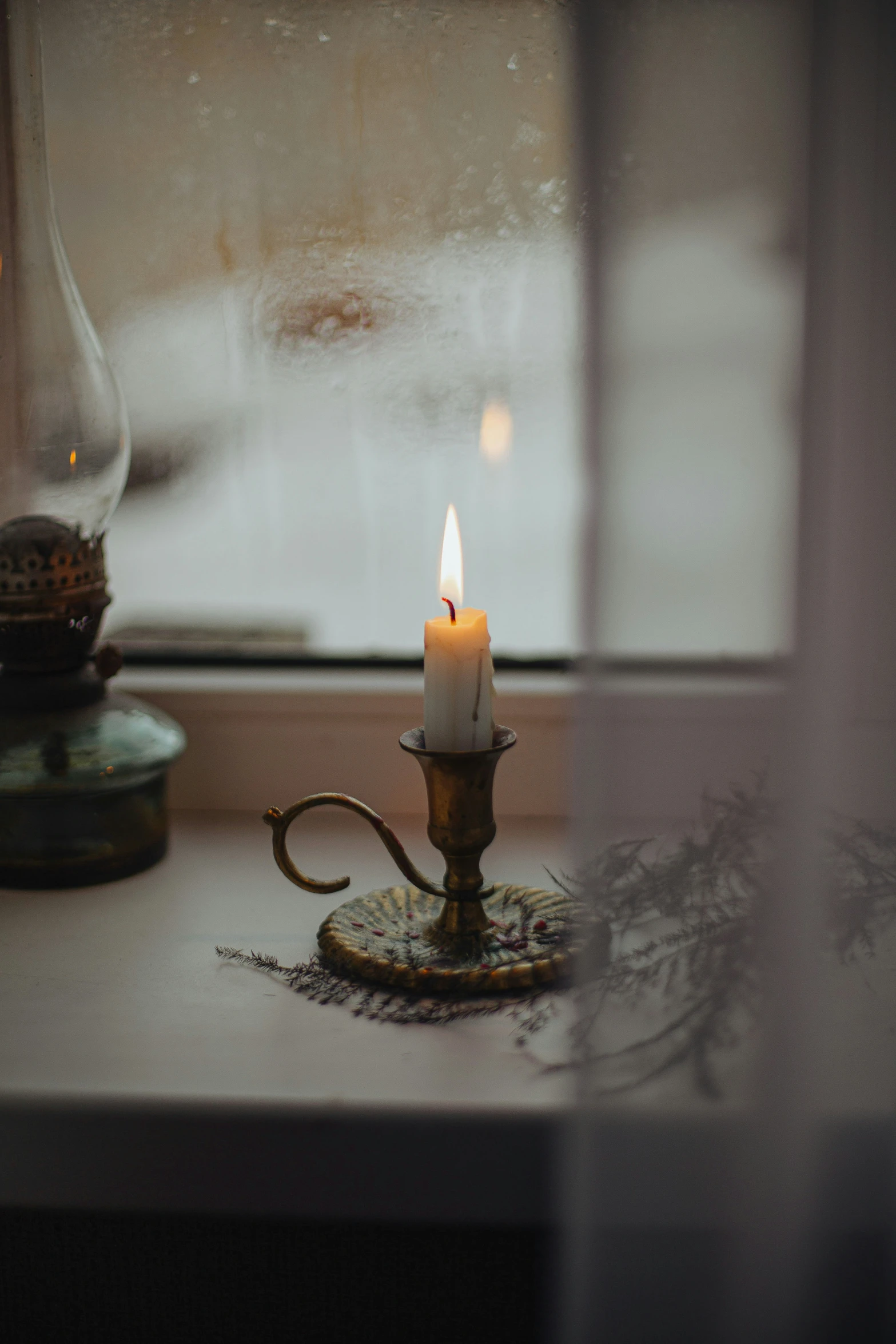 candle in a vintage hook sitting on a table