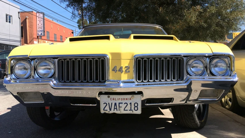 yellow and white classic car parked on the street