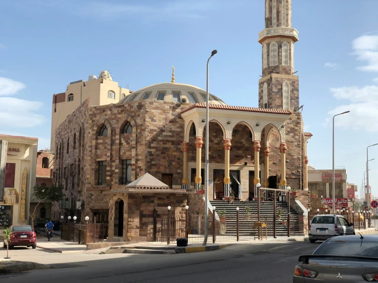 a building with large towers, a clock and stairs on the sides