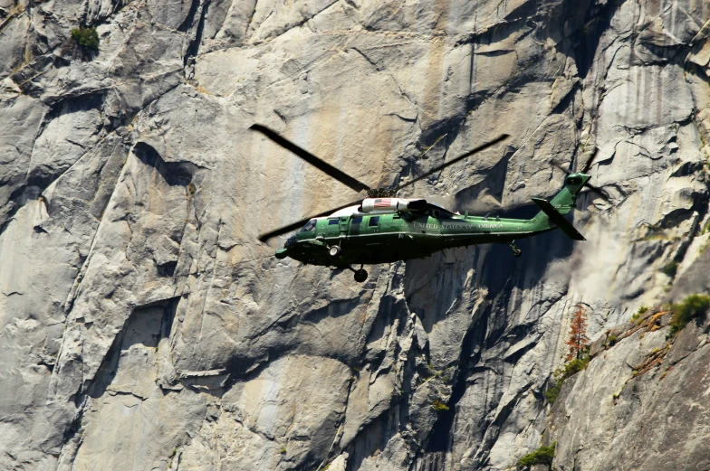 a helicopter flies low above the rocky terrain