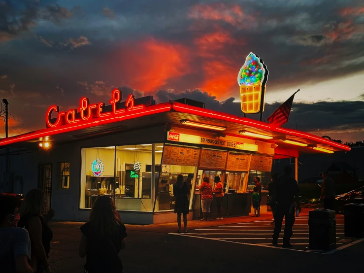 a diner with people standing outside it