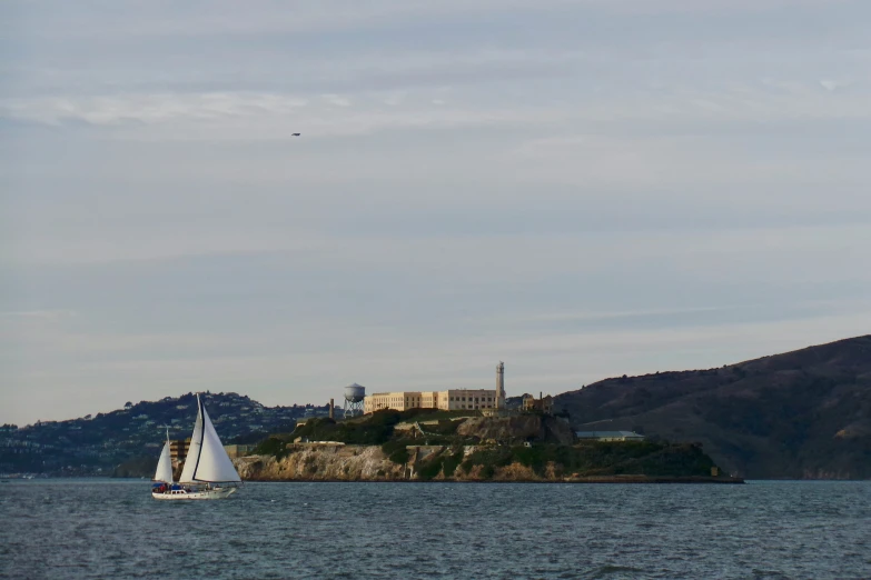 sailboat in a body of water near a mountain range