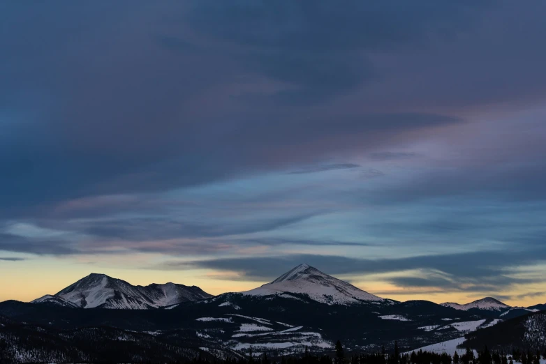 some snow mountains under a cloudy sky