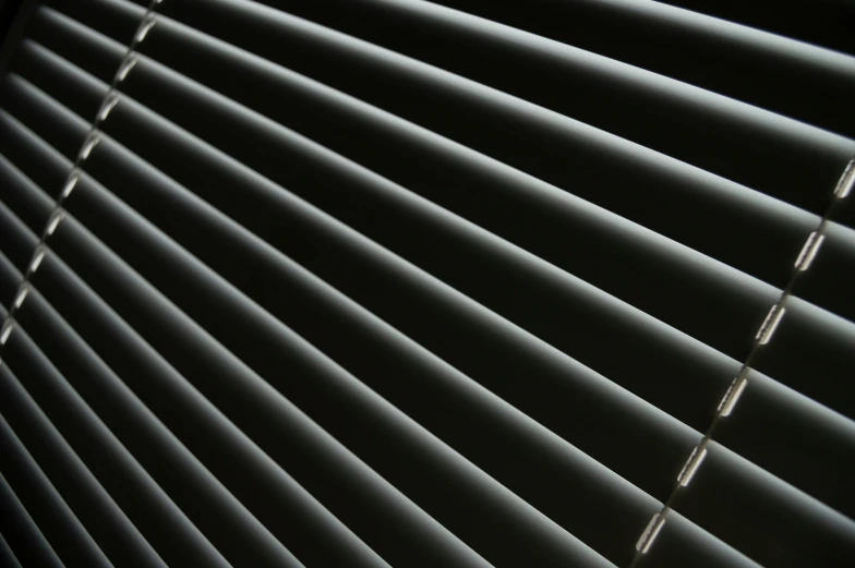 a white corded blind is seen through the blinds