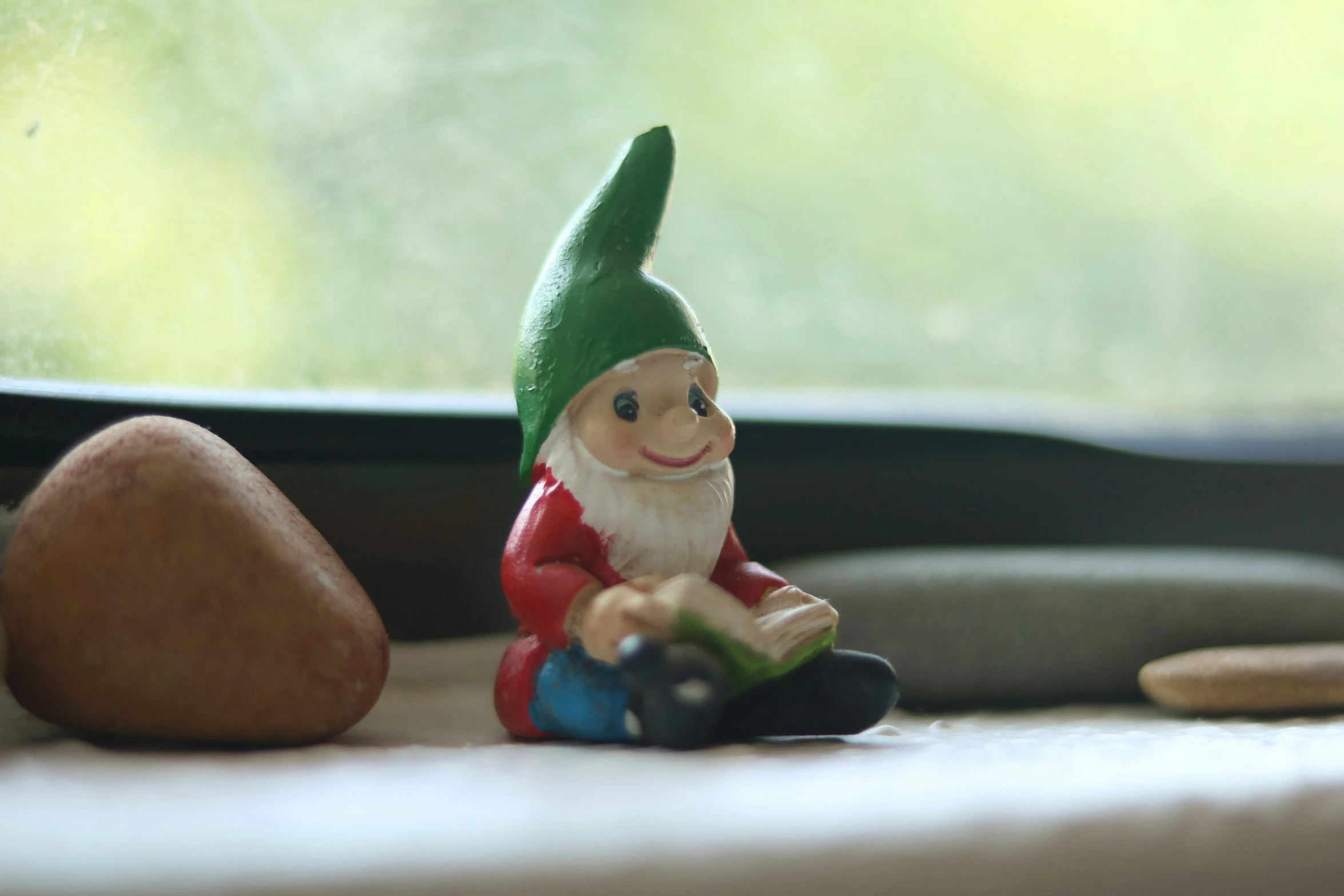 a gnome sitting on the floor with a book in his hand