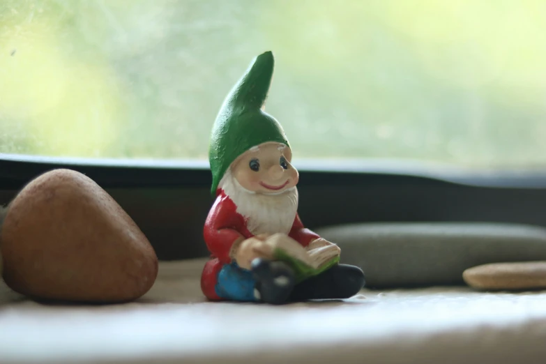 a gnome sitting on the floor with a book in his hand