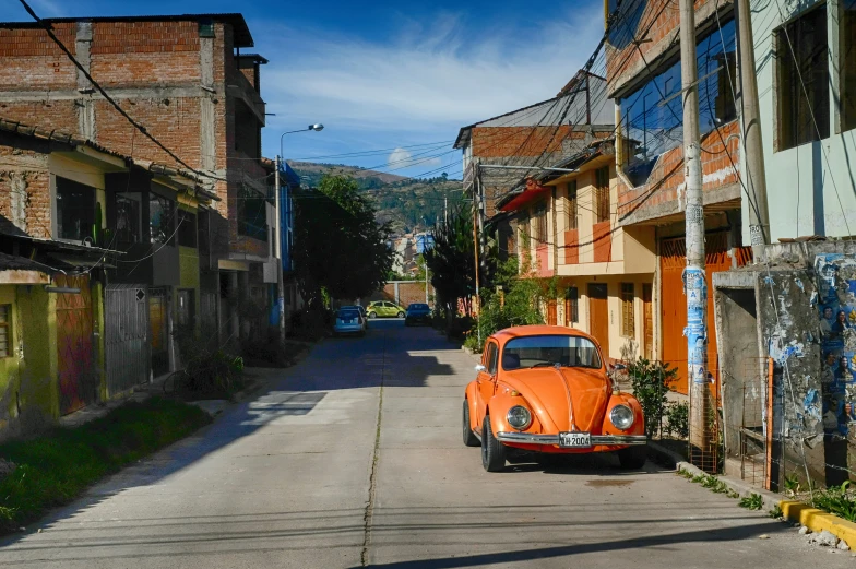 a vintage orange car parked on an alley