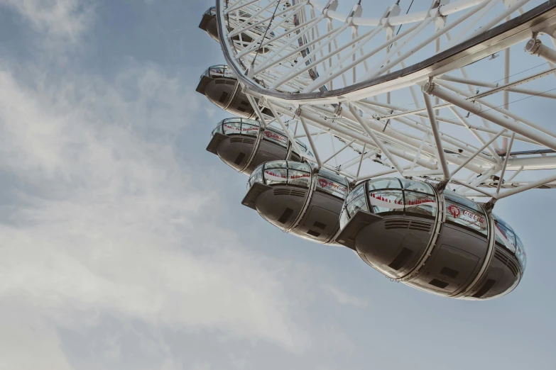 a ferris wheel sitting in the sky against the clouds