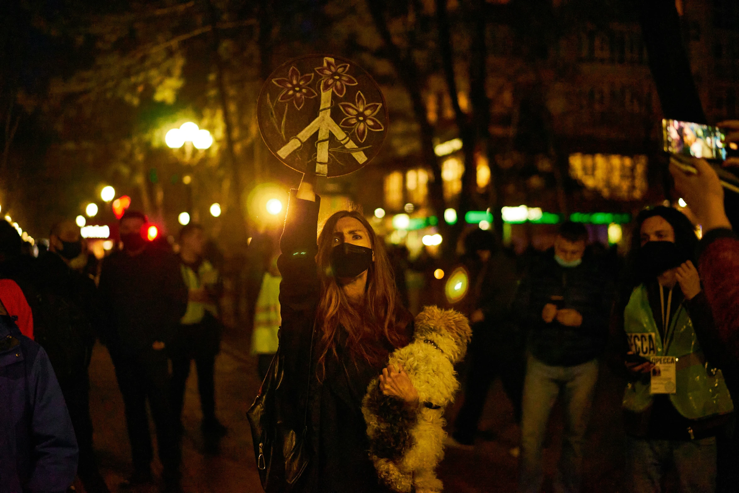 people are gathered outside on the sidewalk at night