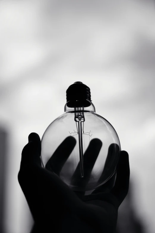 a black and white po of a person holding a glass bottle