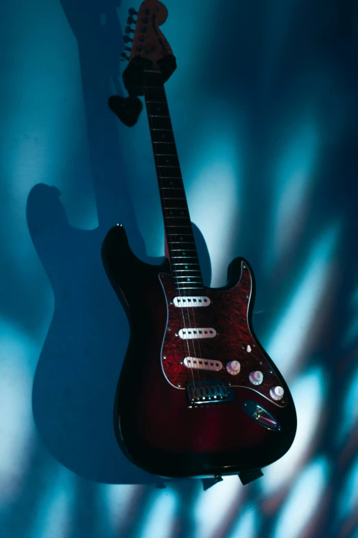 an electric guitar hanging from the wall