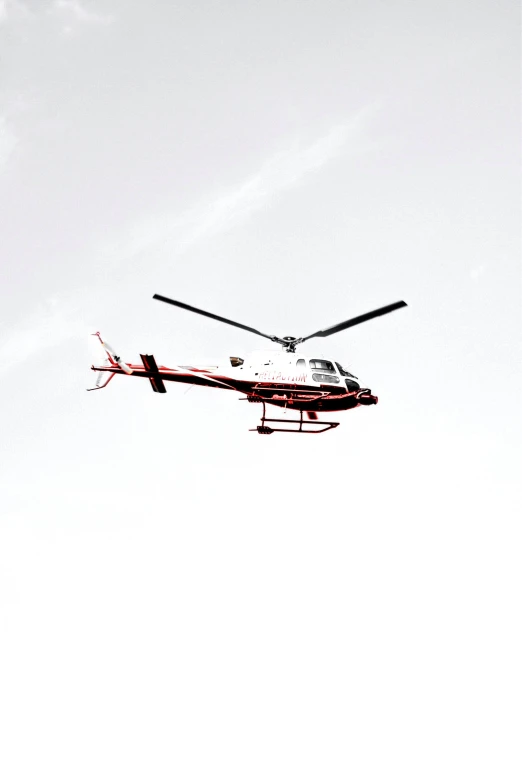 a helicopter flying in the sky near two jet engines