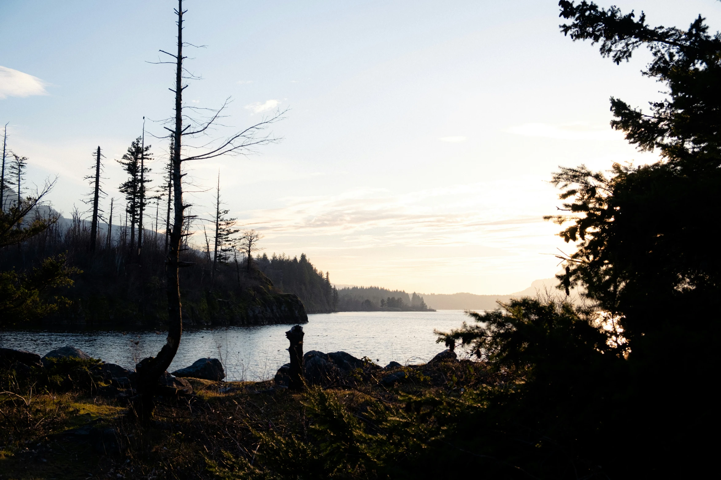 two people are sitting on rocks near the water