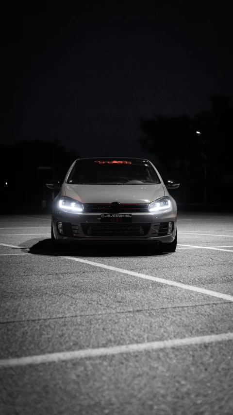 a car parked in the dark on a parking lot