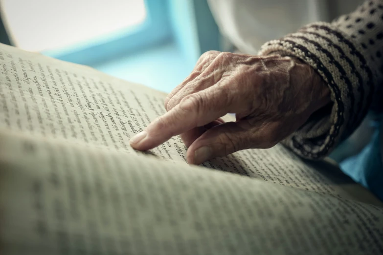 an old woman is reading a book with a ring