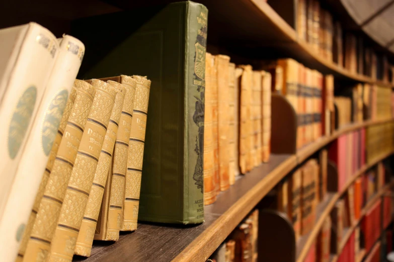 several stacks of books sitting on top of a shelf