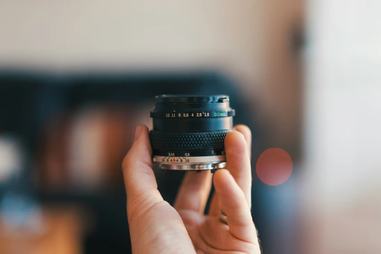 a hand holding a camera in front of the lens