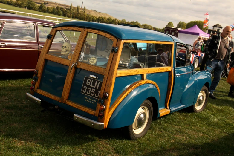 a blue and brown old fashion car at a show