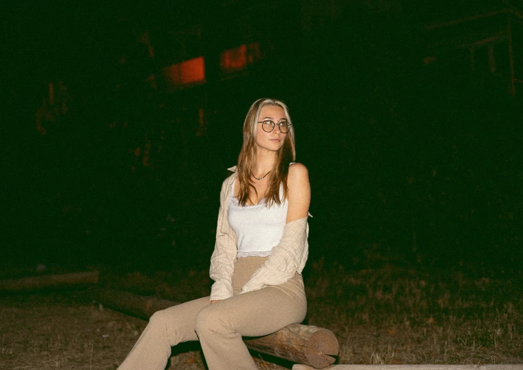 a girl sitting on the ground with her leg up