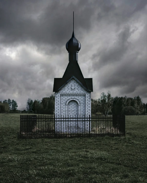 a church and gate on a stormy day with a dark sky behind