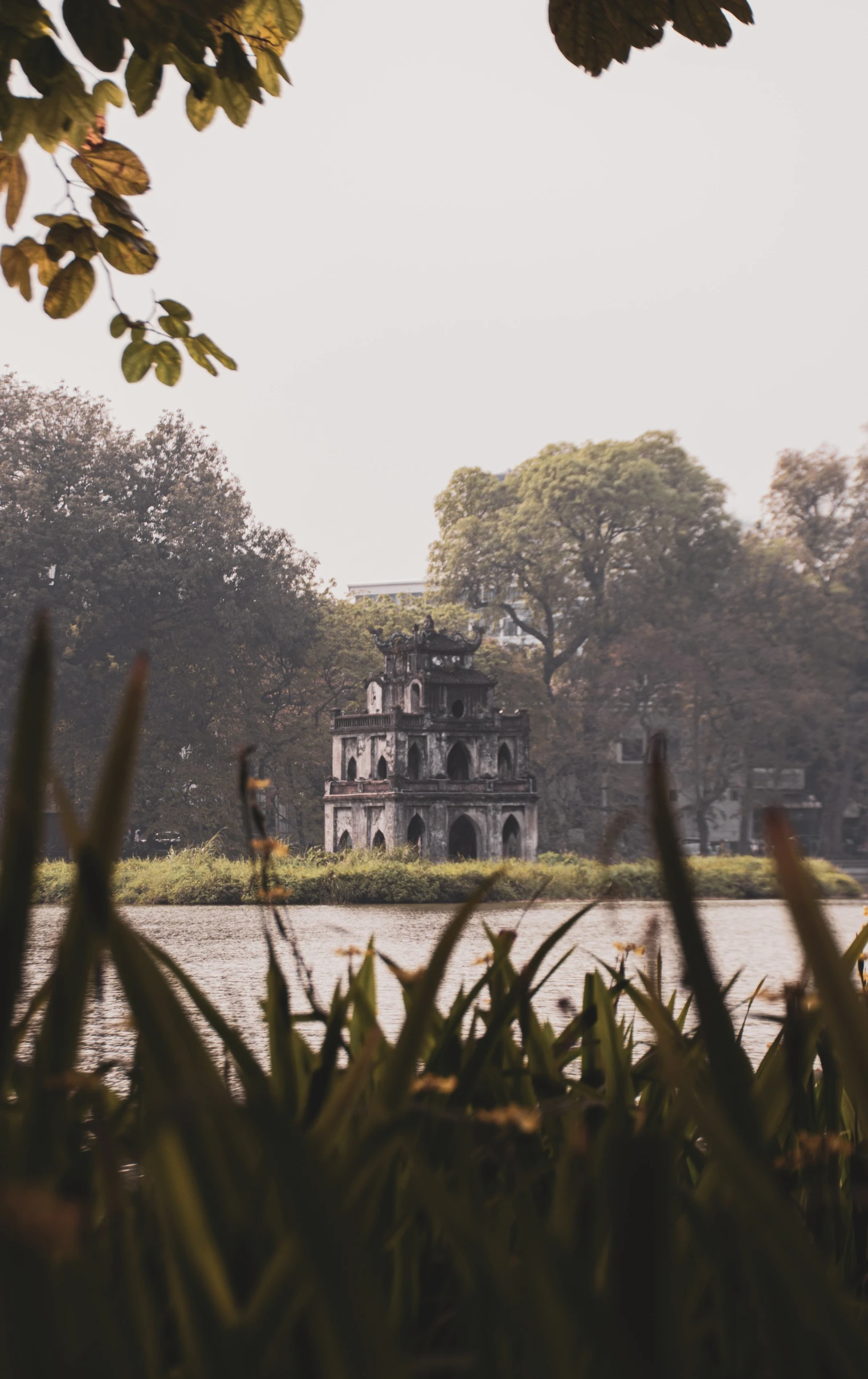 a large building sitting in a forest on top of water