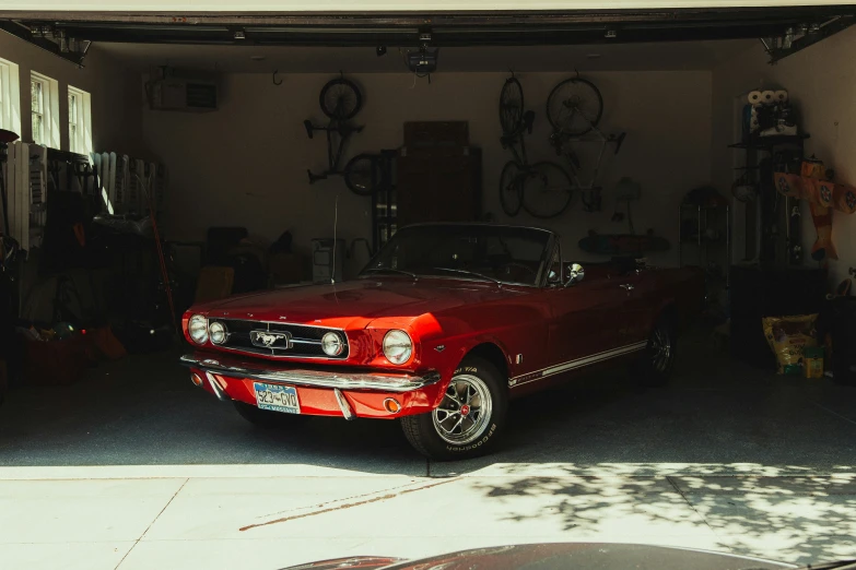 a red mustang is parked in a garage