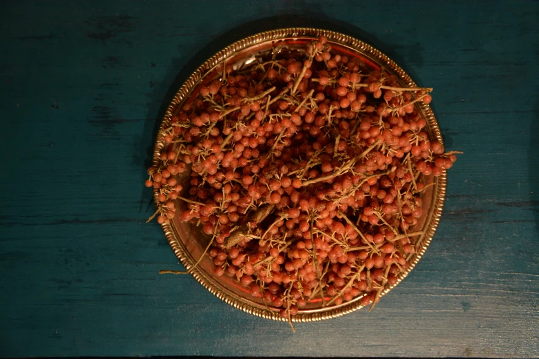 small, ripe berries sit on a metal plate