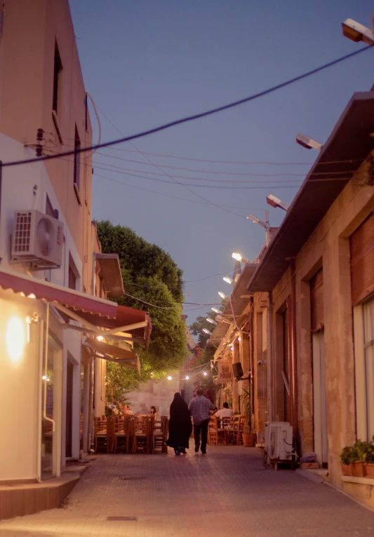 a couple walk down a city street at night