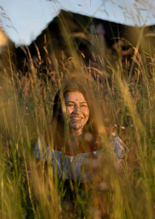 a woman smiling with a house in the background