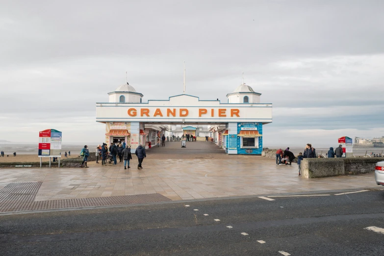 people walking out of a grand pier on a cloudy day