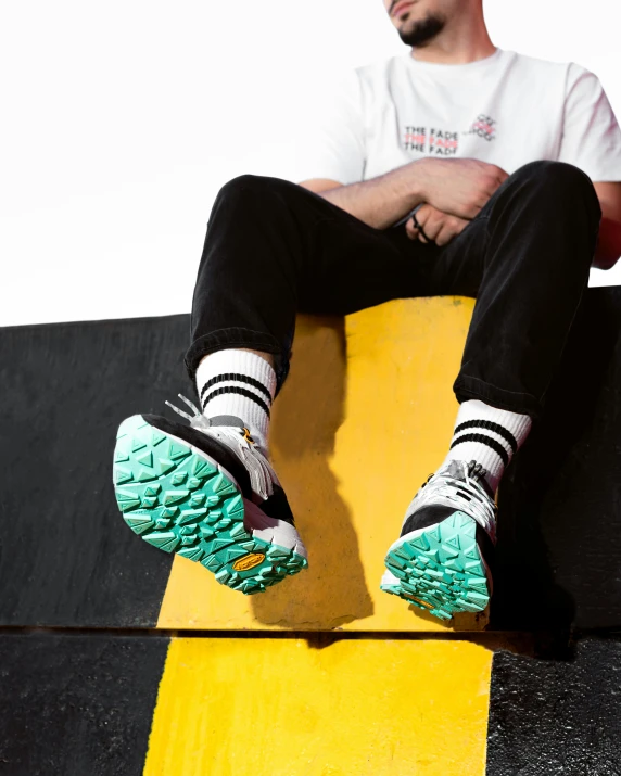 the person wearing black and white socks is sitting on yellow skateboard