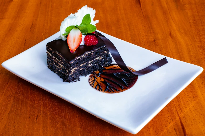 a piece of cake and a chocolate dish is sitting on a white plate