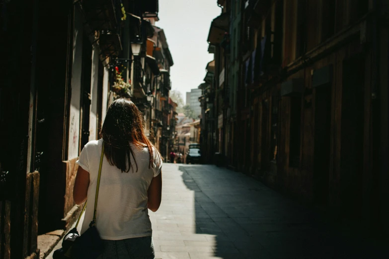 the woman is walking down the street alone