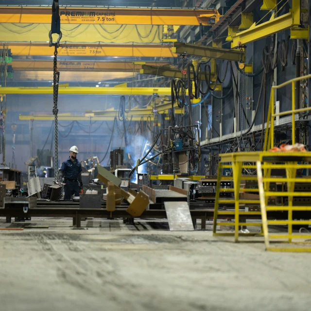 a man with a hard hat looking at some metal